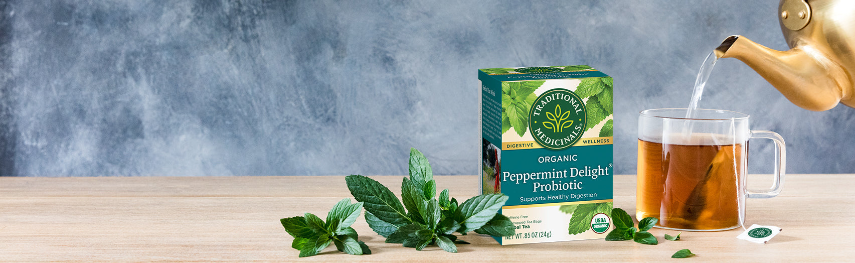 Peppermint Delight Probiotic tea box, cup, and teapot on table
