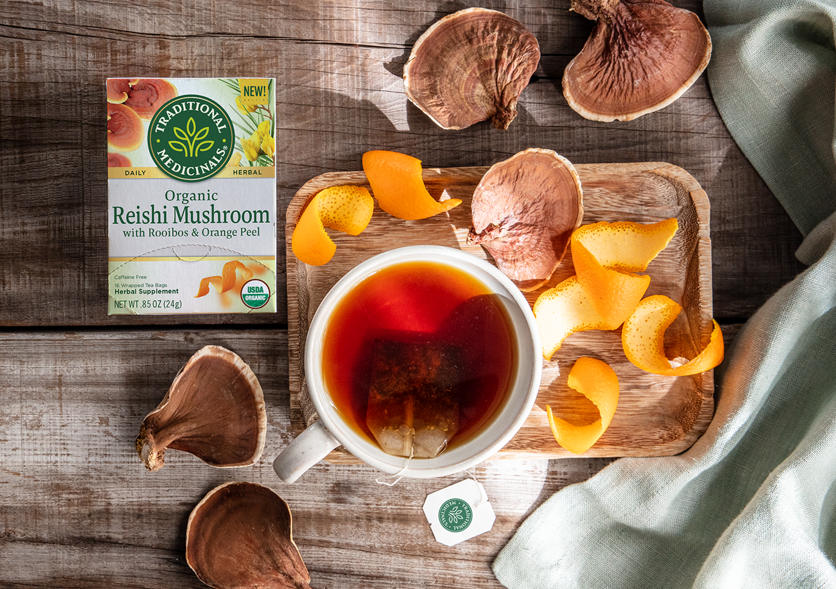 Reishi tea steeping next to fresh reishi mushrooms and orange peel /><p>Our <a href=