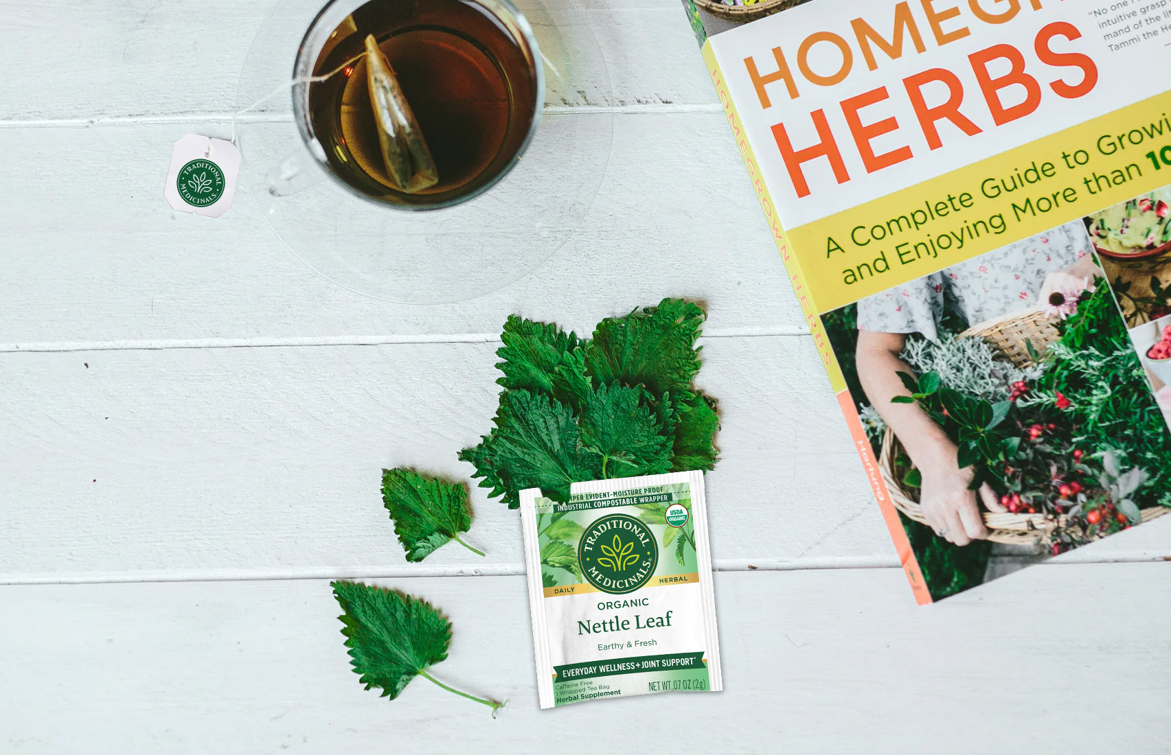 Nettle Leaf tea bag wrapper and Homegrown Herbs book overhead view of table