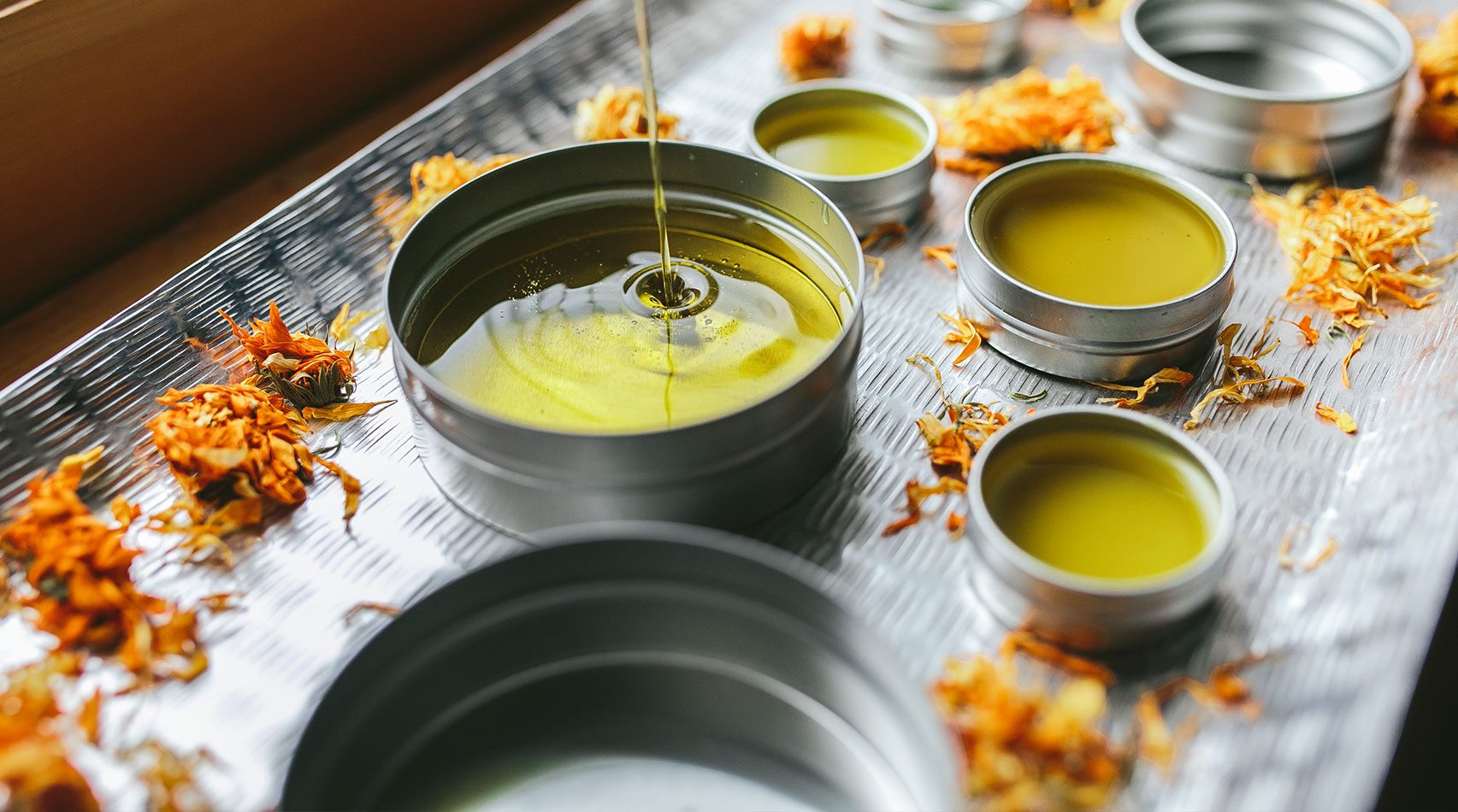 Pouring salve into metal container